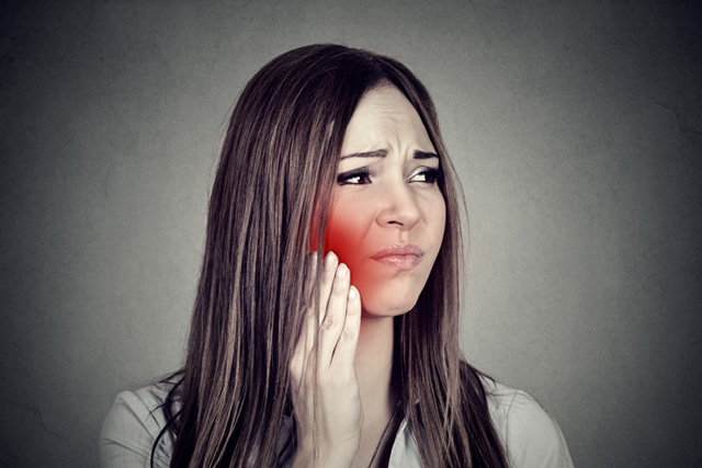 Woman holding painful jaw